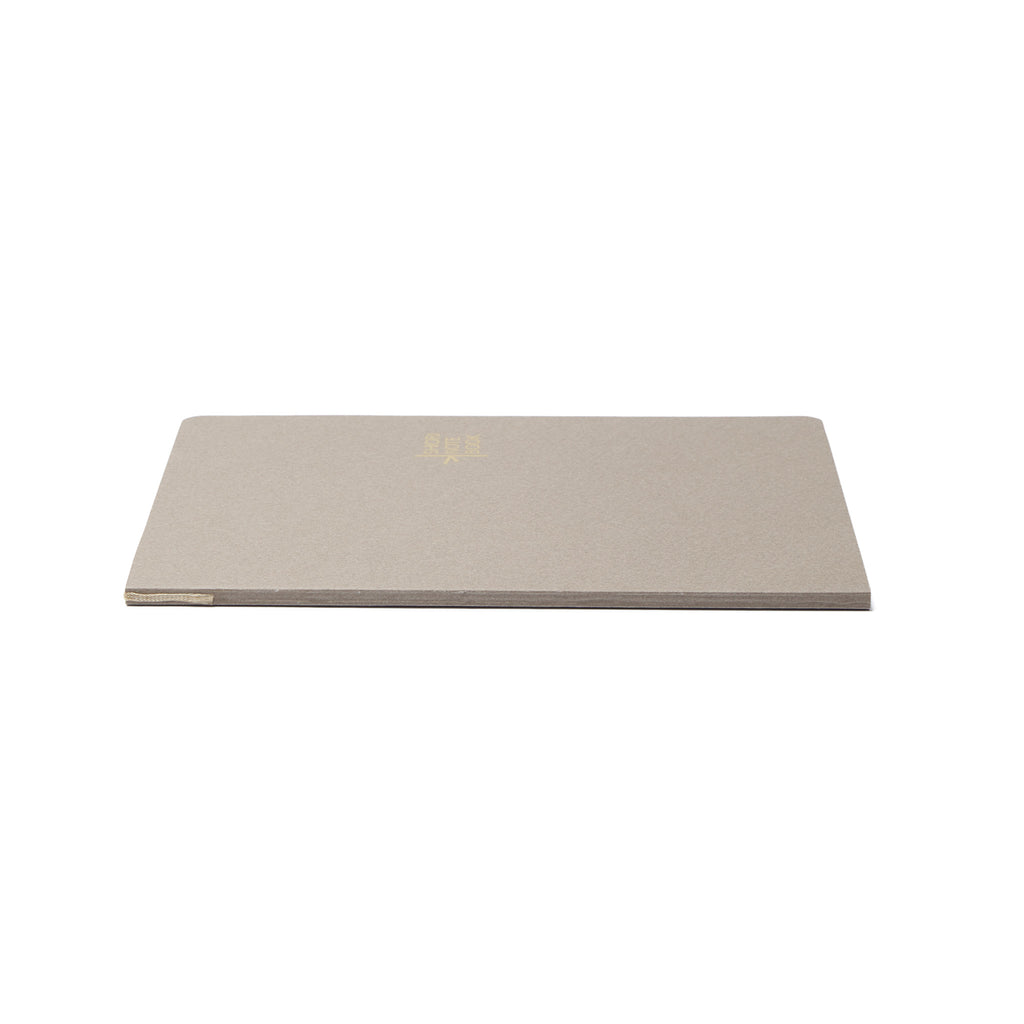 A side profile of the closed Pensift Notebook Refill, showing the slim 80-page spine and how the bookmark ribbon is built directly into the binding.